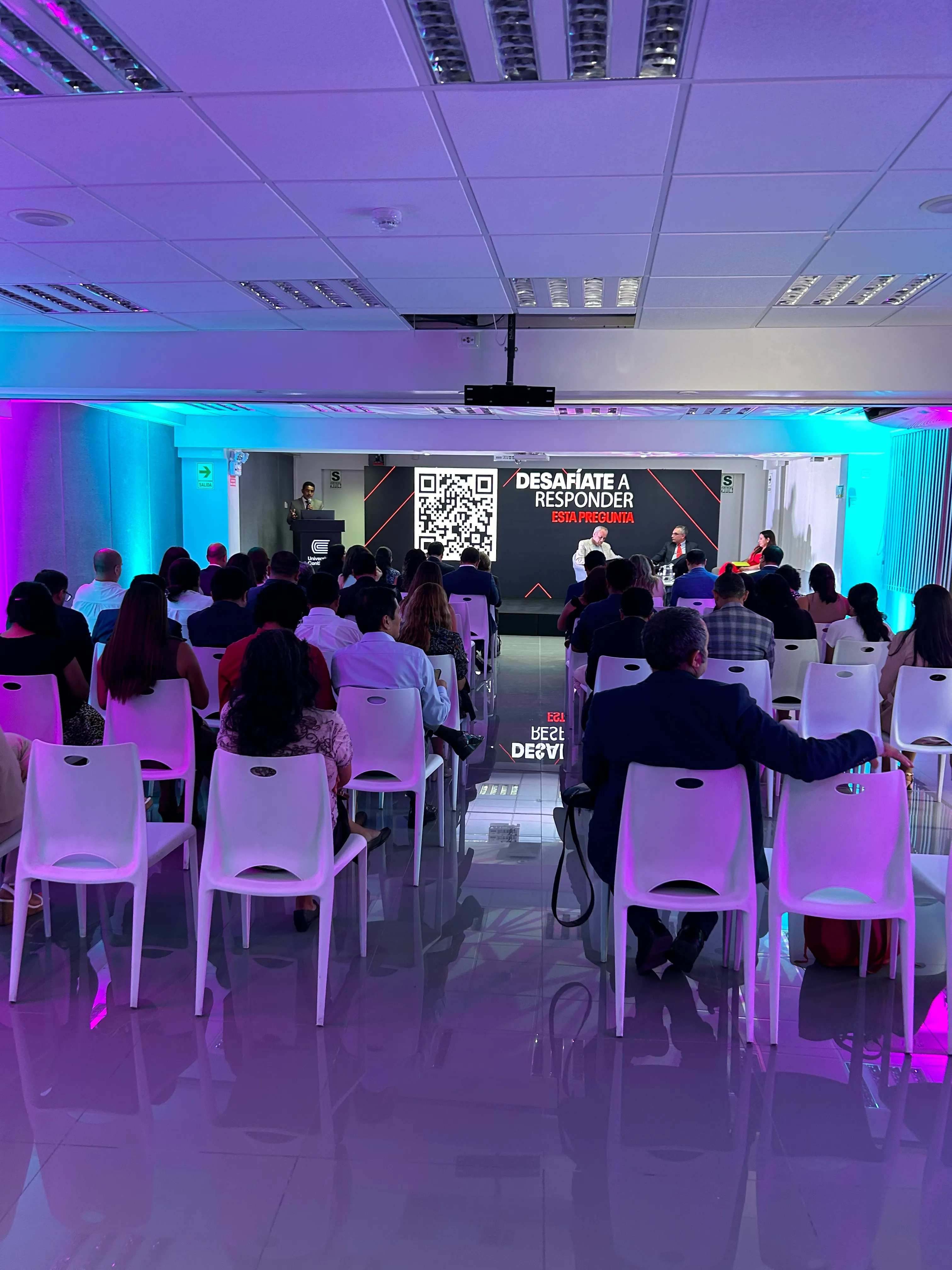 Evento de Universidad Continental con escenario y asistentes